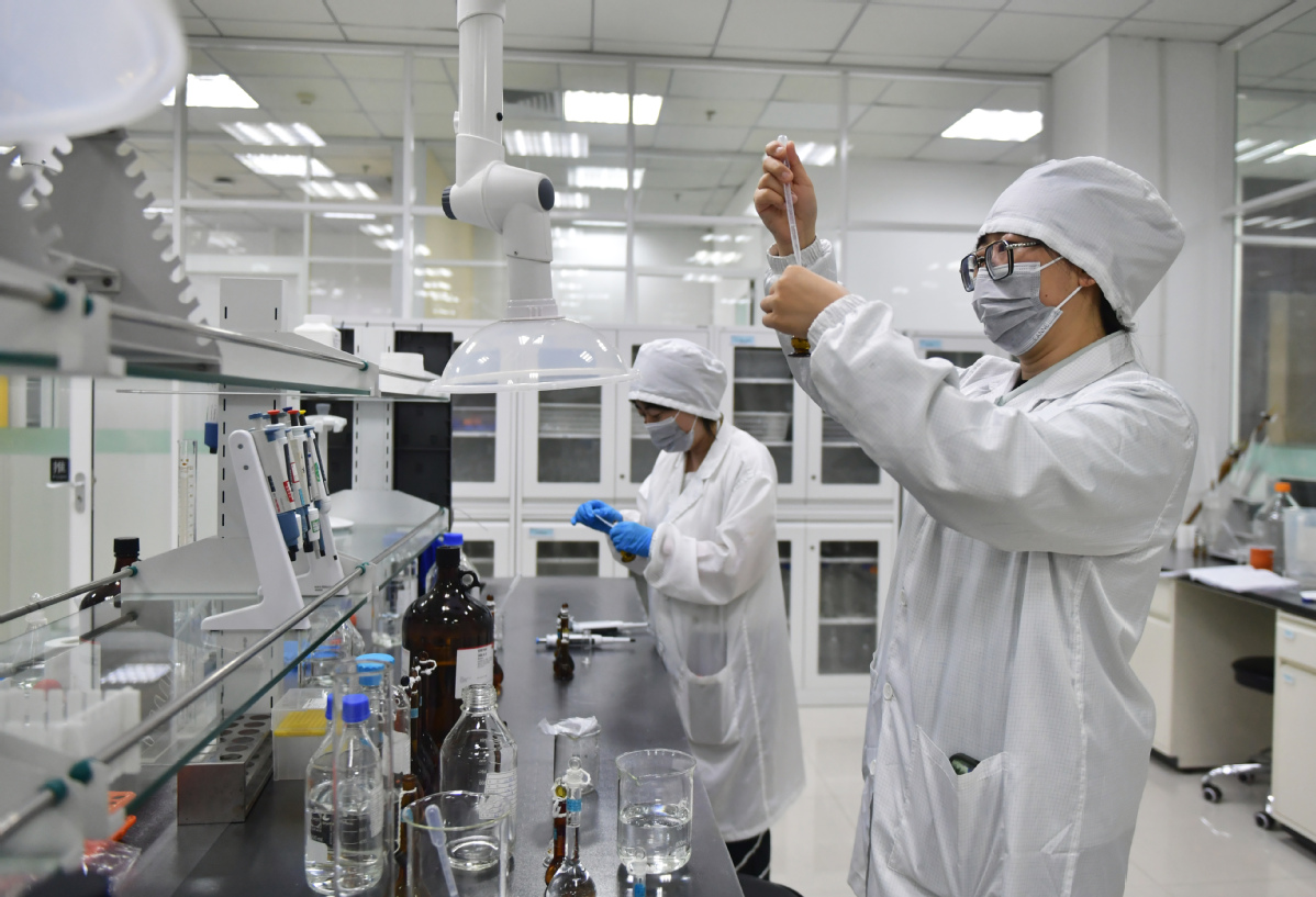 Employees examine drug samples at a laboratory in Shenyang, Liaoning province, in May.jpeg